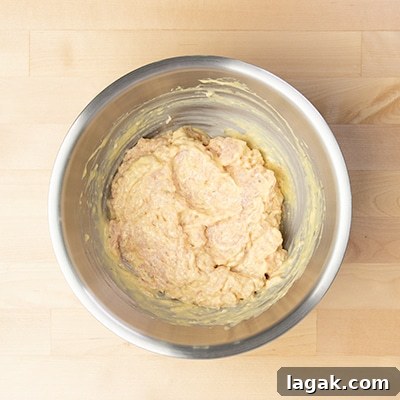 round chicken mixed with yellow mixture in mixing bowl