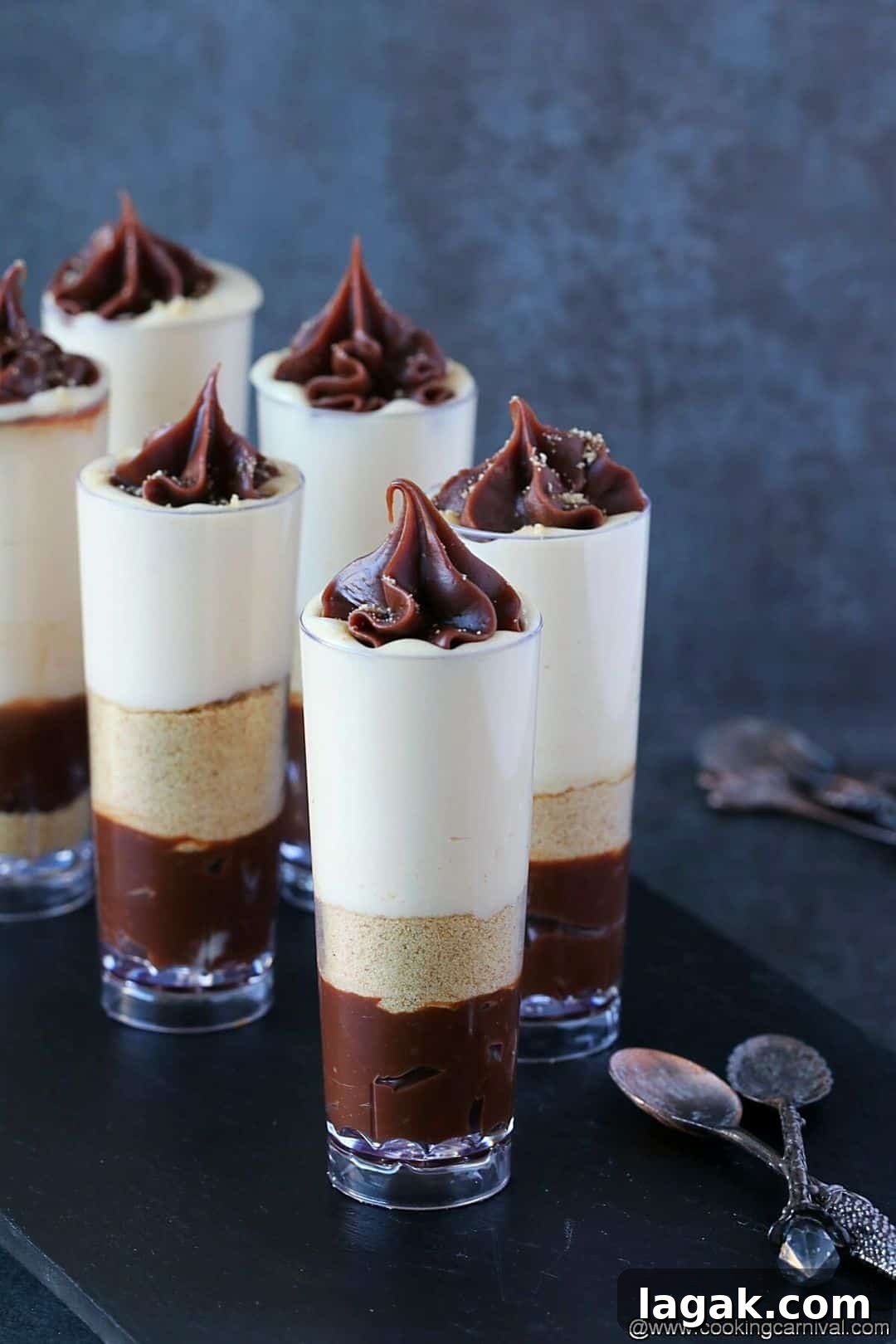 Mini cheesecakes assembled in tall glasses with caramel sauce and chocolate truffle sauce
