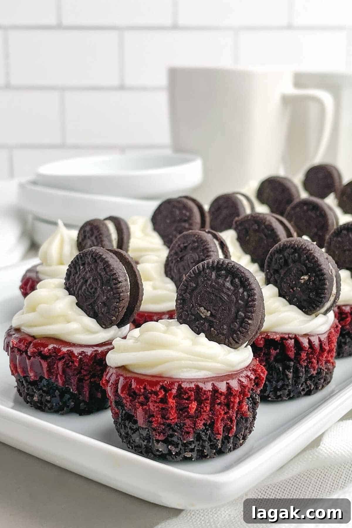 mini red velvet cheesecakes stacked behind one another on a white tray