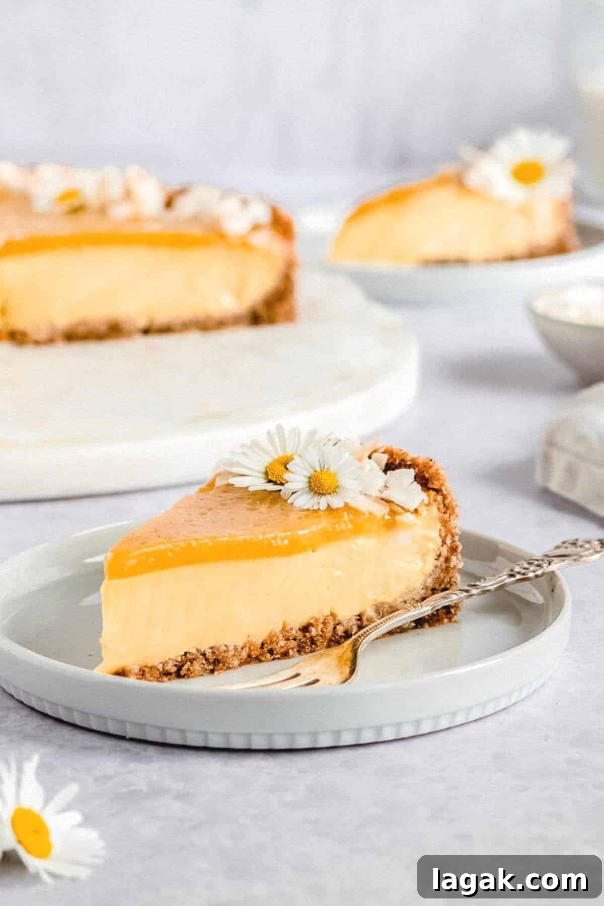 slice of vegan mango coconut cheesecake placed on a grey plate