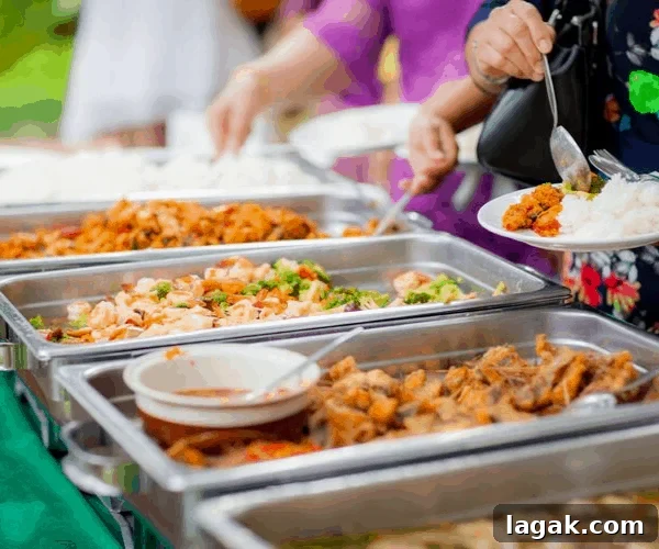 Buffet tables at a party with people serving themselves.
