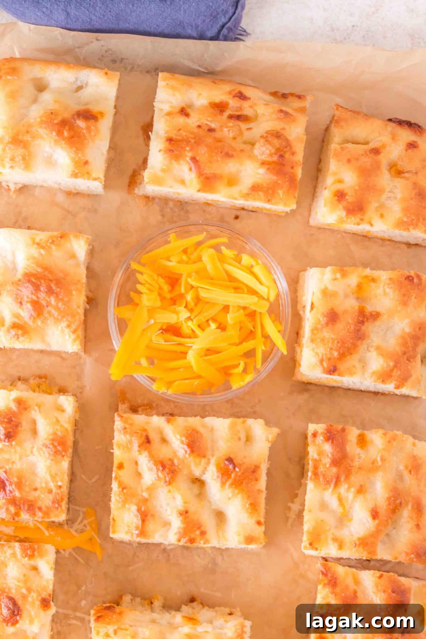 overhead view of slices of homemade cheese focaccia on brown paper
